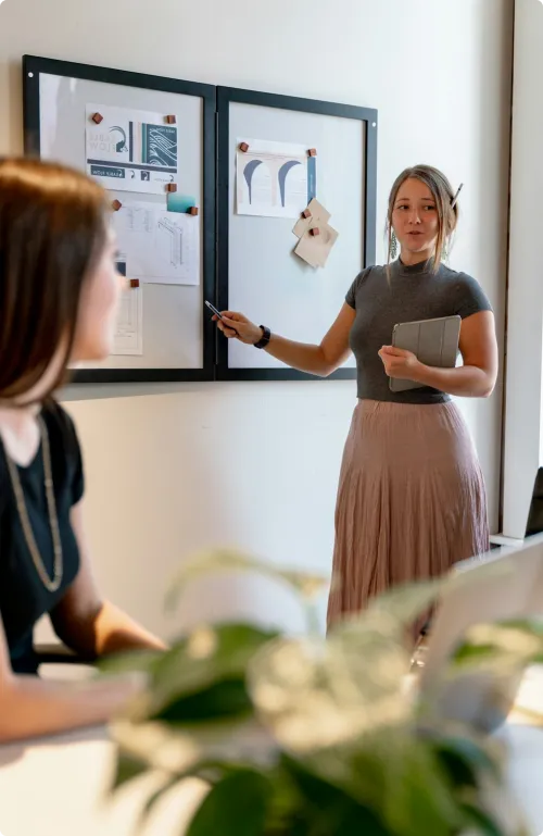Two women in a meeting looking at a chart